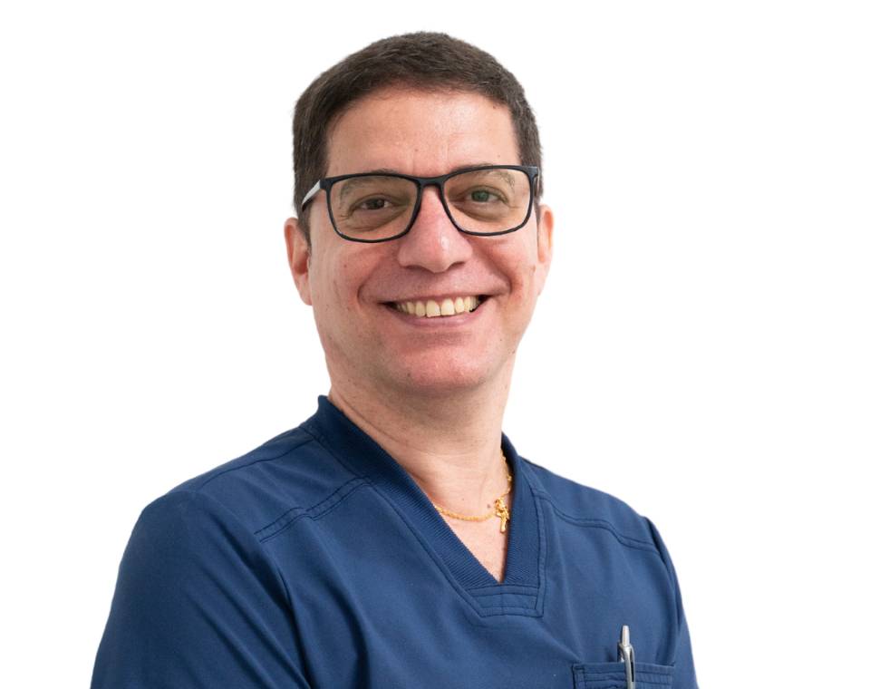 Smiling man wearing glasses and a blue scrub top.