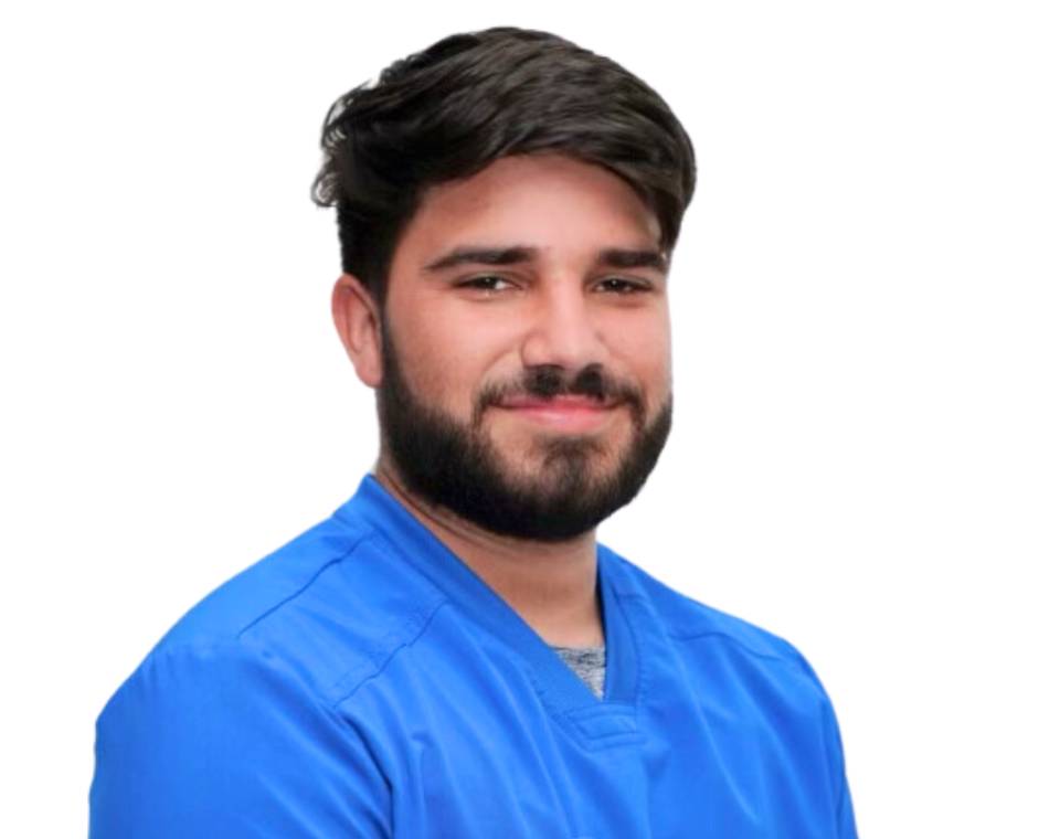 Smiling person with a beard wearing a blue shirt.