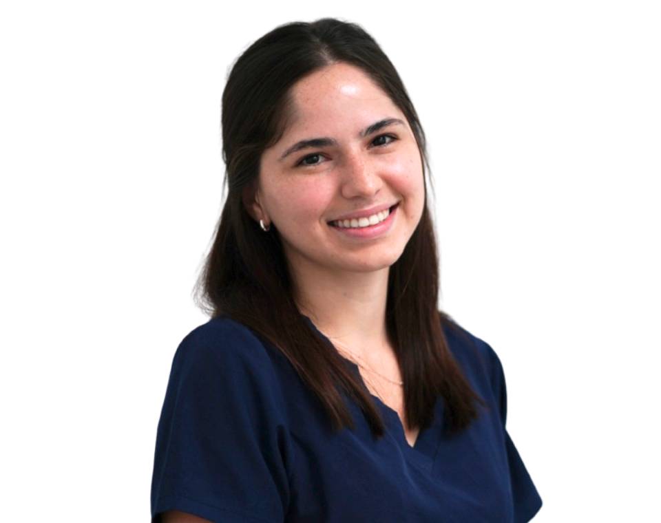 Smiling person with dark hair wearing a navy blue top.